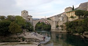 Stari Most, old bridge in Mostar. The camera slowly rises up to reveal a wide shot of the old town