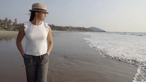 adult woman is relaxing admiring ocean view, walking over beach, calmness and rest