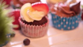 Home made cupcakes on wooden table. Selective focus. Tracking shot.
