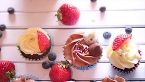 Top view of home made cupcakes on wooden table. Selective focus. Tracking shot.
