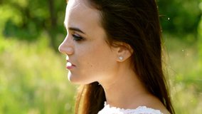 Girl Model in a Romantic Manner in Nature. Lovingly Looking at the Sky and Smiling. Slow Motion Footage. Close Up Shot.