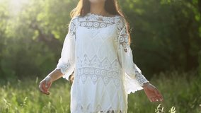Beautiful Girl with Long Hair in the Summer Garden. She has a Delicate White Dress. Her Long Hair Fluttered in the Wind. Slow Motion Footage.