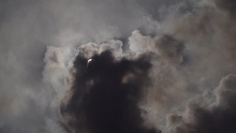 Sun covered by black clouds of smoke