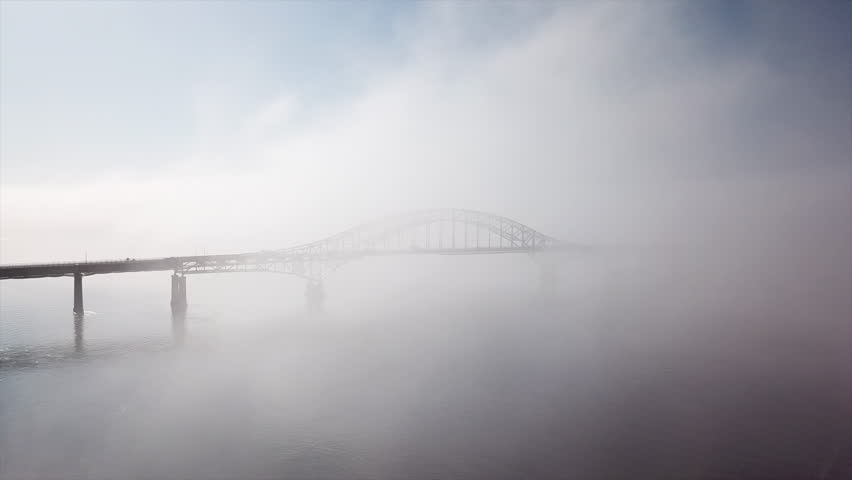 Aerial of bridge emerging from the fog