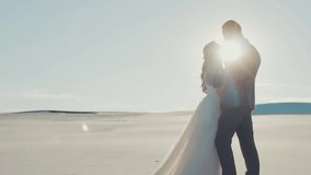delightful crazy romantic video of a couple in love, the bride and groom are full of tenderness and warm feelings, the queen of the desert and her beloved husband, the sunlight shows silhouettes