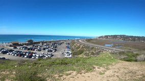 Time lapse video footage of the busy parking lot at Torrey Pines State Park and beach in San Diego, California from above.