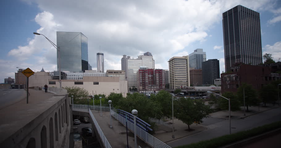 Timelapse view of downtown Atlanta from Castleberry Hill.  Footbridge with some cars driving by. Westin Peachtree Plaza, Centennial Tower and Equitable Building and more in the shot. 