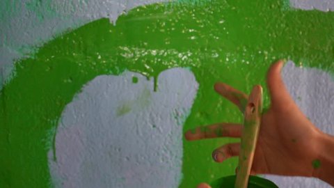 Children paint the wall with oil paint.