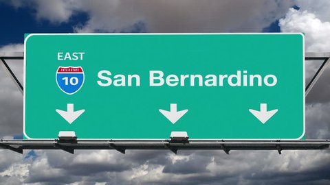 San Bernardino California interstate route 10 overhead freeway directional arrow sign with time lapse clouds.