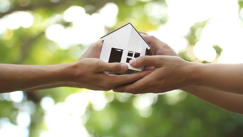 Hands hold a house and giving to the owner. Building or Buying a new house, loan, Architecture House desing concept.