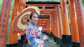 Asian women in traditional japanese kimonos at fushimi inari shrine in Kyoto, Japan. Smiling woman.