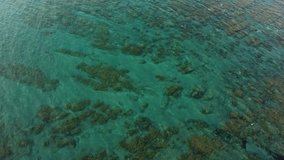 Video from the air (quadrocopter) over the turquoise sea of Cyprus. Algae, rocks and corals can be seen in the clear water. Beautiful white rocky wild beach . Paradise landscape