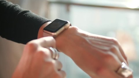 Woman using smartwatch touchscreen wearable technology device. Closeup.