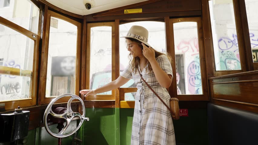 Cheerful young woman inside of retro tram on street in Lisbon