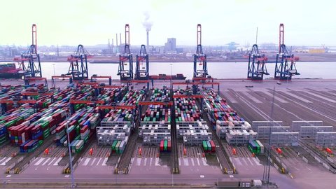 Aerial flight over Rotterdam harbour in Netherlands industrial landscape storage containers clear blue water 4k