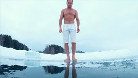 Young man swims in the ice hole. Slow motion version of the clip.