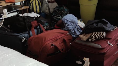 A Messy Room with Clothes, Handbags and Luggage Abandoned or Stored across the Floor.