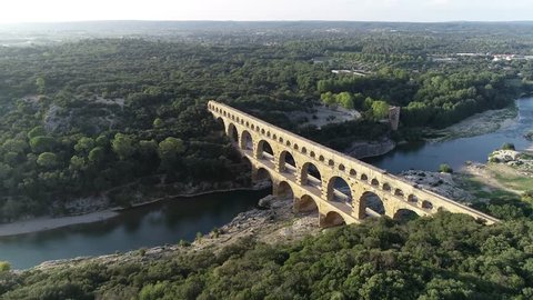 Aerial bird view footage Pont du Gard is ancient Roman aqueduct that crosses Gardon River near towns of Remoulins Avignon and Nimes in southern France it is on UNESCO's list of World Heritage Sites 4k