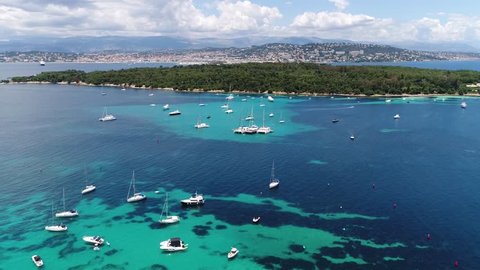 Aerial footage of Plateua du Milieu recreational boats at anchor and Ile Sainte Marguerite which is the largest of Lerins Islands, about half a mile off shore from the French Riviera town of Cannes 4k