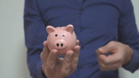 businessman makes savings puts coins in a piggy bank. piggy bank business concept. lifestyle slow motion video. saving money is an investment for the future. Banking investment and finance. hand is