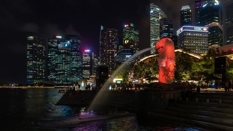 SINGAPORE - FEBRUARY 14, 2019: Time lapse the Merlion fountain lit up with urban cityscape in Merlion Park. Merlion fountain is the symbolic and most famous tourist attraction in Singapore