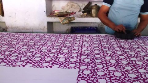 JAIPUR, INDIA - MAY 11, 2017:  Indian man doing wood block printing for textile in India by hand, traditional handicrafts on linen, cotton or silk cloth to create a colourful pattern . Editorial Stock Video