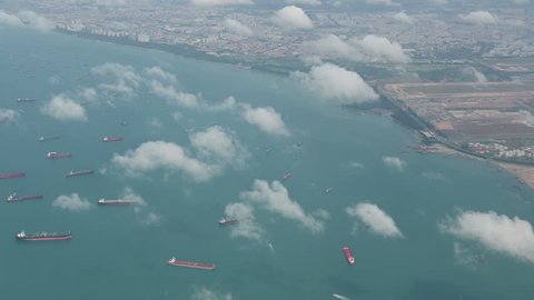 4K Aerial view of many container ships anchored at water area against port terminals