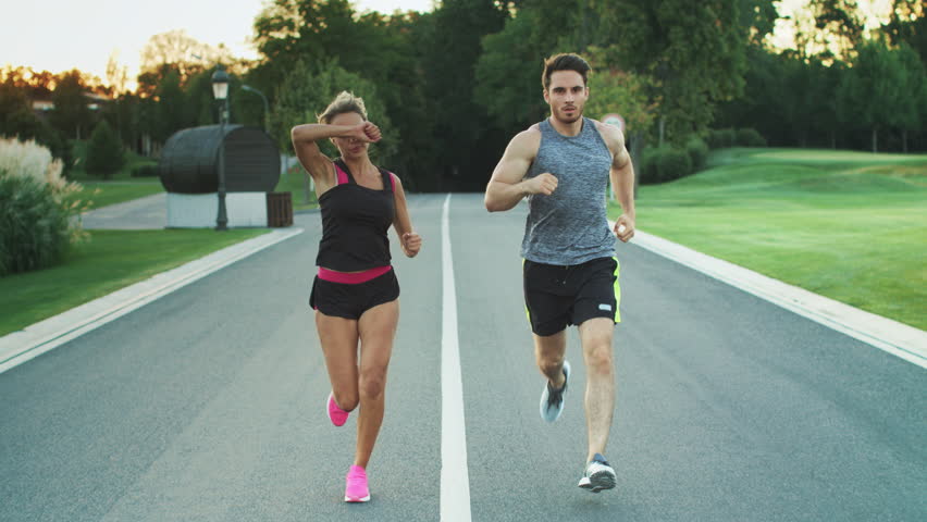 Sport couple run together in park. Young people jogging together at fitness training outdoor. Man and woman at sport training together