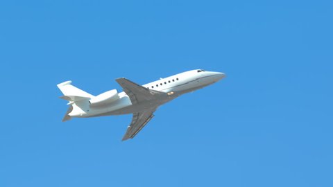 Generic Unmarked Executive Jet Close-up Flying Up into a Clear Blue Sky on a Sunny Day