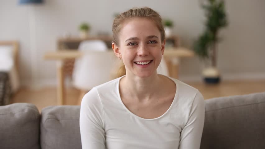 Happy teen girl laughing out loud at humorous joke looking at camera at home, cheerful casual young woman with funny face sit on sofa enjoy sincere positive emotions screaming with laughter concept Royalty-Free Stock Footage #1024307183
