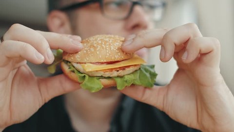 man eating a hamburger. close-up shot. Fast food eats