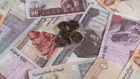 Egypt pound notes and coins slow rotating. Egyptian money currency. Low angle. 4K stock video footage