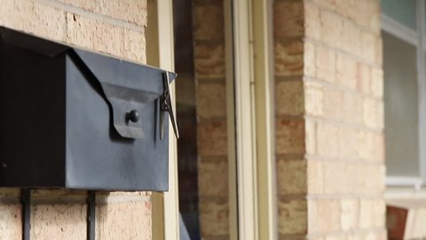 Senior Woman Steps Out of Her Front Door to Check the Mailbox