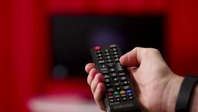 Men's hand with TV remote TV channel switching