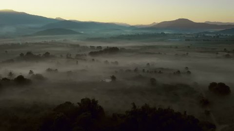 Aerial scene fly over mountain and fog 
 rice field and tree plantation in sunrise time 4k video