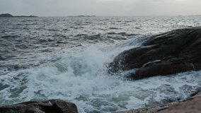 Waves hitting rocks. Evening shot. Dark ocean, white waves. Slow motion.