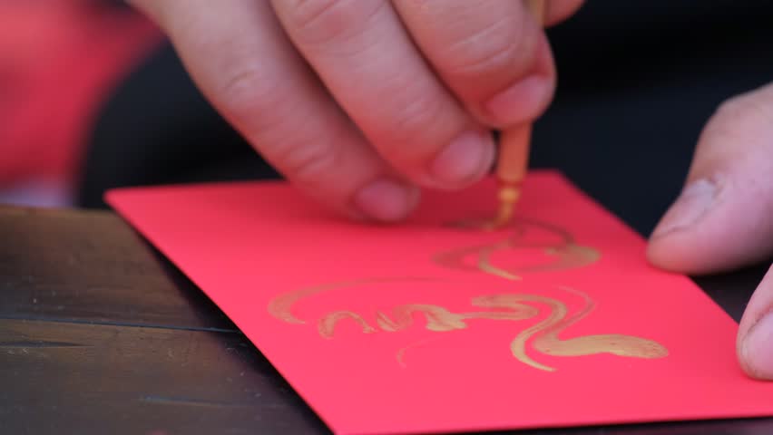 Vietnamese scholar write calligraphy at lunar new year. Calligraphy festival is a popular tradition during Vietnam Tet holiday. Calligrapher draw handwriting in penmanship at fair in springtime Royalty-Free Stock Footage #1024324814