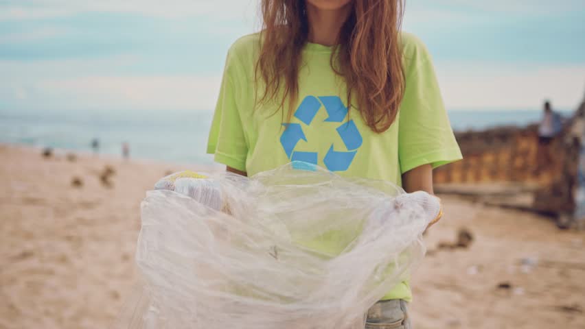 The volunteers working together while picking up garbage on the ocean beach. Group of volunteers cleaning up beach. Volunteering and recycling concept. Environmental awareness concept copy space Royalty-Free Stock Footage #1024333589