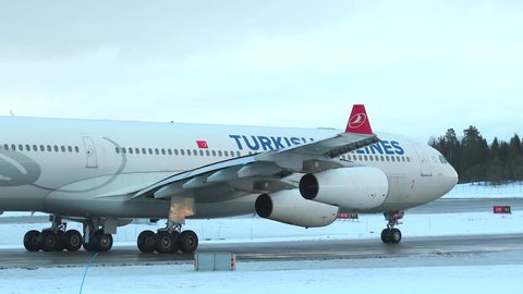 oslo airport norway - ca january 2019: huge airplane turkish airlines a340 taxiing detailed view engines main gear winter scenery