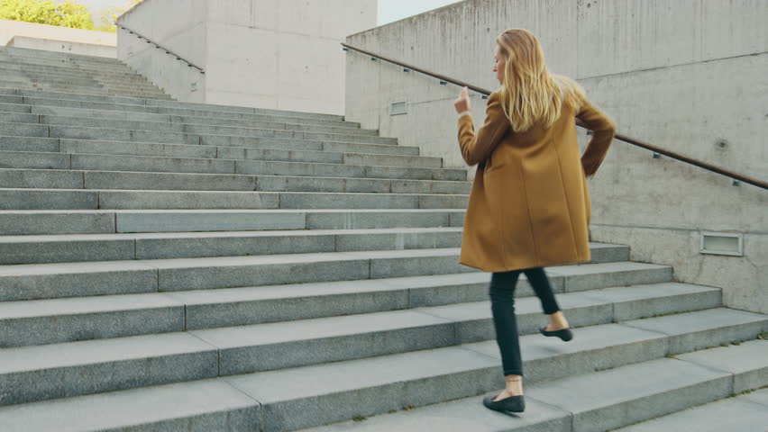 Cheerful and Happy Young Woman Actively Dancing While Walking Up the Stairs. She