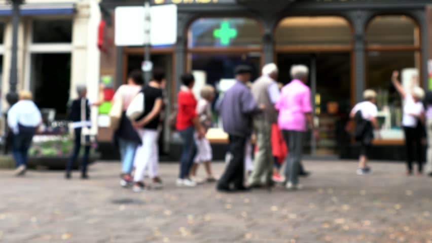Tourists at old stone-covered street at small European town. 4K. Blurred view