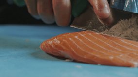 Chef in gloves cuts red fish with sharp knife. Slow Motion Video