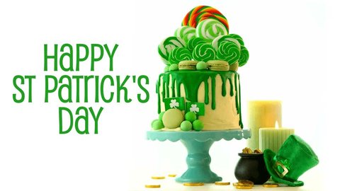 St Patrick's Day party table with lollipop candyland drip cake on white background, animated text greeting.