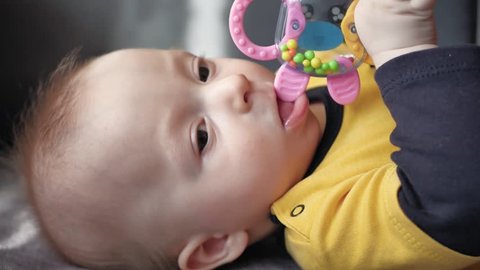 Cute 5 month old baby boy, playing with a teething toy