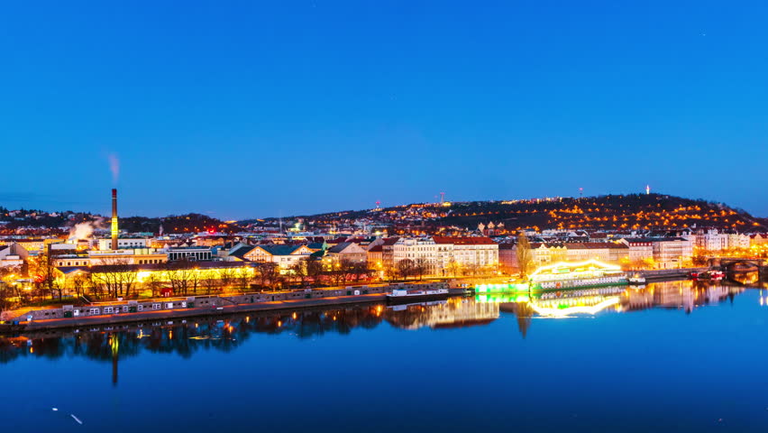 Prague, Czech Republic. Aerial view of Prague, Czech Republic at sunrise with cloudy sky and reflection in the river. Time-lapse, zoom in