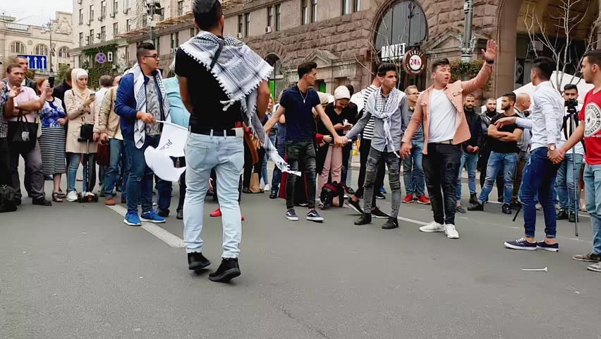 Ukraine, Kiev, September 9, 2018: random men dance on Khreshchatyk Street. Bearded man with drum spinning in the center of a circle. Celebration. Turkish community.
