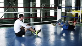 Two muscular men trains in the gym together doing push-ups for abdomen and throwing heavy sportive ball during the process. Concept of: workout, boxing workout, power, hard work - Powered by Shutterstock - Get 15% off with code: PIKWIZARD15