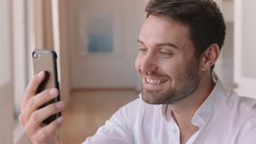 happy young man having video chat using smartphone looking surprised enjoying good news chatting on mobile phone