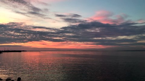 Handheld pan of beautiful sunset over calm sea