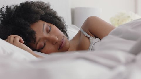beautiful african american woman waking up in bed after restful sleep smiling happy ready for new day